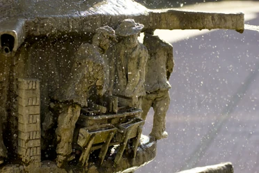 Marktplatz_Brunnen_Detail_01©Tourist-Information Lage.jpg Wasser spritzt aus einem kunstvoll gestalteten Brunnen mit detailreichen Figuren in enger Interaktion.
