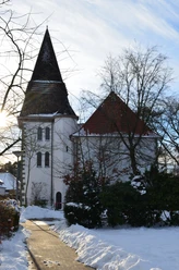 Verschneite St. Joseph-Kirche in Liemke; historisches Gebäude mit markantem Turm im Winterlicht.