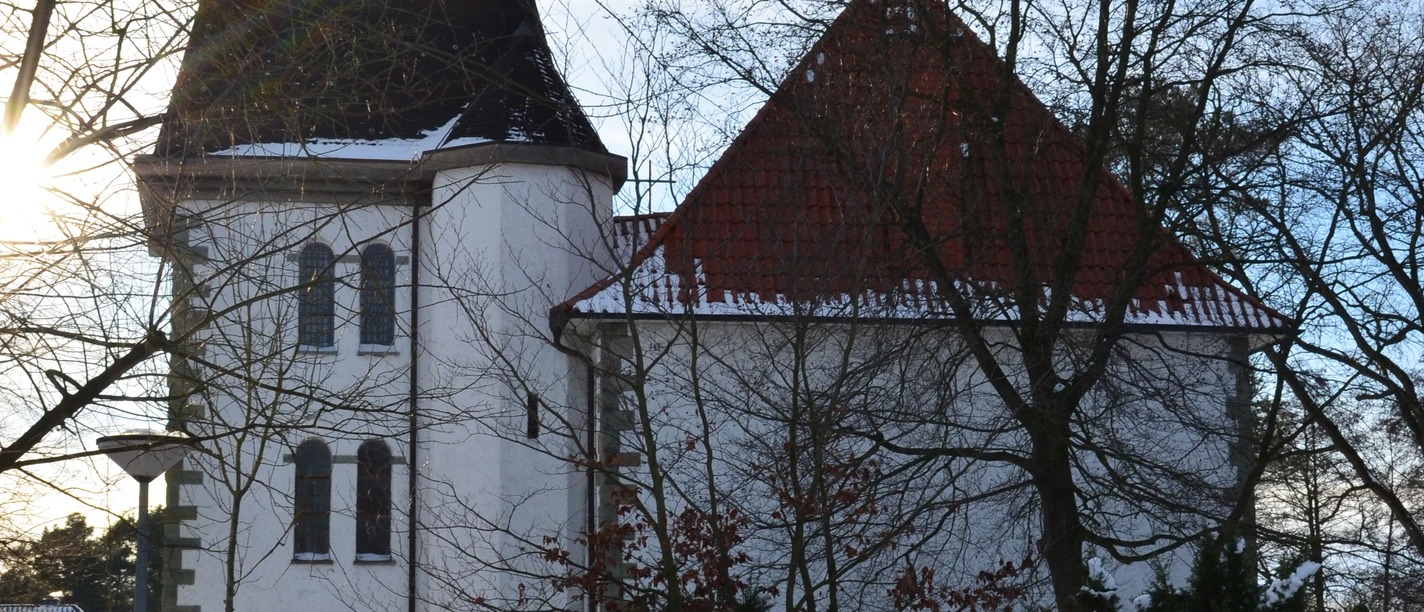 Verschneite St. Joseph-Kirche in Liemke; historisches Gebäude mit markantem Turm im Winterlicht.