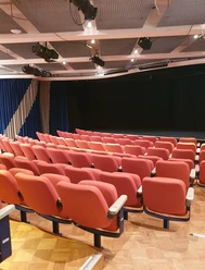 Das Bild zeigt Theatersitzplätze und die Bühne