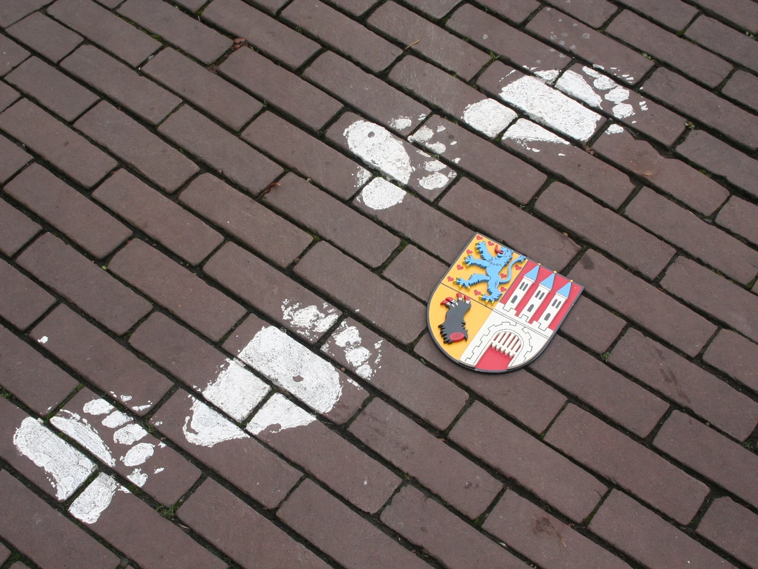 Nienburger Bärenspur Spur von Bärentatzen und Stadtwappen auf gepflastertem Weg in Nienburg, Anregung zum Stadtrundgang.Trace of bear paws and town coat of arms on a cobbled path in Nienburg, suggestion for a tour of the town.Spor af bjørnepoter og byvåben på en brostensbelagt sti i Nienburg, forslag til en rundtur i byen.Sporen van berenpoten en het stadswapen op een geplaveid pad in Nienburg, suggestie voor een rondleiding door de stad.