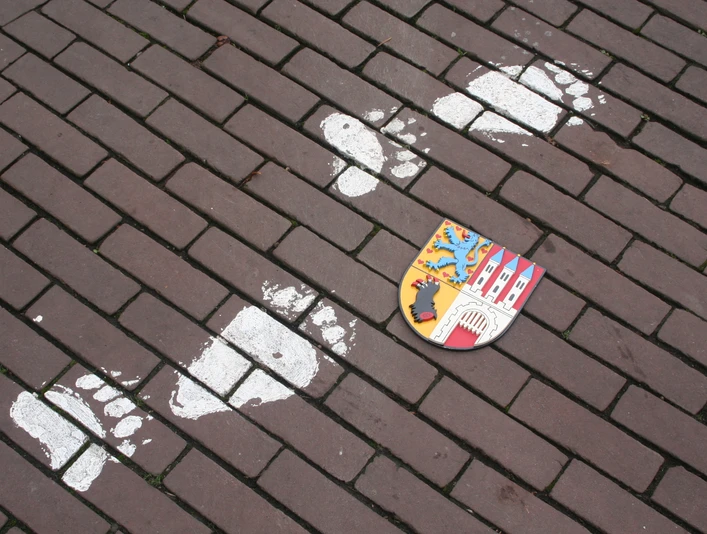 Nienburger Bärenspur Spur von Bärentatzen und Stadtwappen auf gepflastertem Weg in Nienburg, Anregung zum Stadtrundgang.Trace of bear paws and town coat of arms on a cobbled path in Nienburg, suggestion for a tour of the town.Spor af bjørnepoter og byvåben på en brostensbelagt sti i Nienburg, forslag til en rundtur i byen.Sporen van berenpoten en het stadswapen op een geplaveid pad in Nienburg, suggestie voor een rondleiding door de stad.