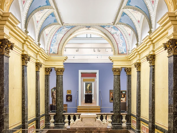 Ein Museumsraum mit kunstvoll gestalteten und gewölbten Decken und mit Gold verzierten Säulen aus schwarzem Marmor..