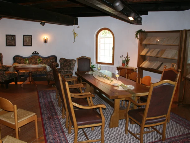 Ein rustikales Trauzimmer mit Holzmöbeln, gewölbten Fenstern und elegantem Dekor für Hochzeiten.