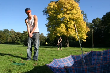 Junger Mann spielt Crossgolf im Park in Leipzig das vom Friezeitanbieter betourt ausgerichtet wird, Erlebnis