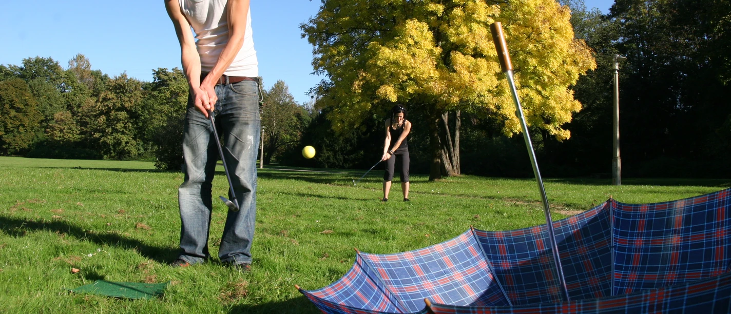 Junger Mann spielt Crossgolf im Park in Leipzig das vom Friezeitanbieter betourt ausgerichtet wird, Erlebnis