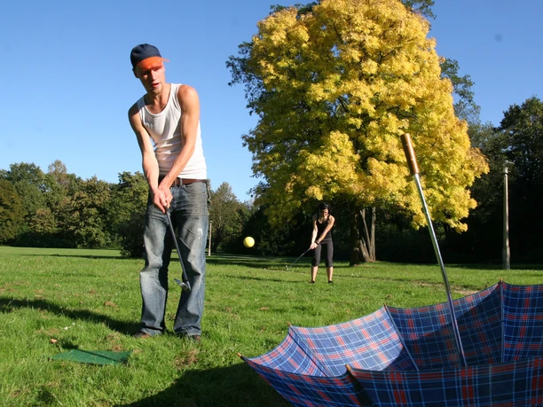Junger Mann spielt Crossgolf im Park in Leipzig das vom Friezeitanbieter betourt ausgerichtet wird, Erlebnis
