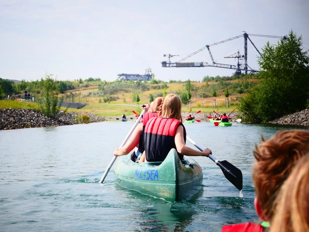 ALL-on-SEA Bootsverleih Markkleeberger See Kanufahrer mit Schwimmwesten paddeln am Markkleeberger See , im Hintergrund das Industriedenkmal Bergbau-Technik-Park, Freizeit, Wassersport, Kanufahren, Aktiv