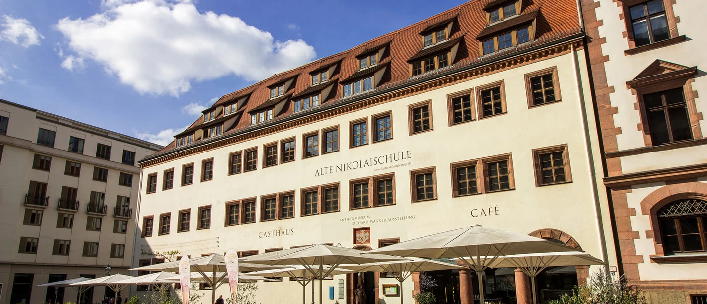 Vue sur la façade de la Alte Niklaischule à l'église Saint-Nicolas dans laquelle se trouvent à la fois un restaurant et un musée sur Richard Wagner, gastronomie à Leipzig, institution culturelle, ville de musique