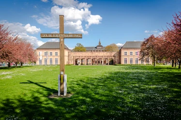 Alter Johannisfriedhof - Kultureinrichtungen in Leipzig Blick auf das Holzkreuz das an die zerstörte Johanniskirche erinnert und das Gebäude der Grassi Museen für Völkerkunde Musikinstrumente und angewandte Kunst am Johannisplatz in denen man wunderbare Ausstellungen betrachten kann, Kultureinrichtung in Leipzig, Museum, Geschichte, Kultur