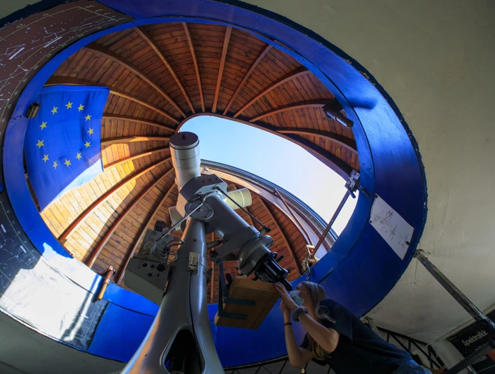 Astronomisches Zentrum Schkeuditz - Sehenswürdigkeiten in der Leipzig Region Blick ins Innere des Observatoriums, an dem eine junge Frau durch das Teleskop in den Himmel schaut, Wissenschaft, Observatorium, Sternwarte, Freizeit