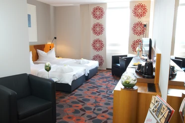 Chambre de luxe à l'hôtel Atlanta - Hébergement dans la région de Leipzig Vue intérieure de la chambre d'hôtel avec lit double, fauteuil et autres aménagements intérieurs, hébergement, vacances, court séjour