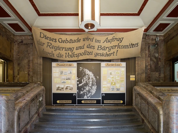 Museum in der "Runden Ecke" - Museen in Leipzig Blick auf einen Treppenaufgang im Foyer vom Museum in der Runden Ecke in der eine Ausstellung über die Zeit der DDR und SED zu sehen ist, Kultureinrichtungen, Geschichte von Leipzig, Friedliche Revolution
