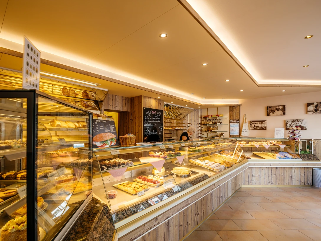 Bäckerei und Konditorei Göbecke - Cafés in Leipzig Blick in die Bäckerei und Konditorei Göbecke sowie auf die lange, erleuchtete Ladentheke, Kulinarik, Gastronomie