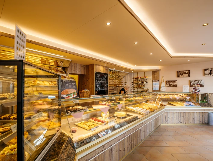 Bäckerei und Konditorei Göbecke - Cafés in Leipzig Blick in die Bäckerei und Konditorei Göbecke sowie auf die lange, erleuchtete Ladentheke, Kulinarik, Gastronomie