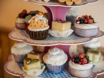 Bäckerei und Konditorei Göbecke - Cafés in Leipzig Das Bild zeigt eine Étagère mit bunten Cupcakes und Pralinen der Bäckerei und Konditorei Göbecke, Süßwaren, Konditorei