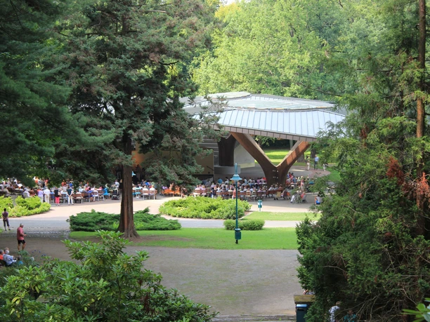 Kurpark Bad Lausick - Sehenswürdigkeiten in der Leipzig Region Blick in den grünen Kurpark und auf die Schmetterlingsbühne, vor der viele Menschen bei einer Open Air Veranstaltung sitzen, Freizeit, Kultur, Veranstaltungen