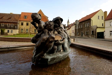 Sackhupperova kašna v popředí a řada domů na trhu v Schildau, kultura, památky