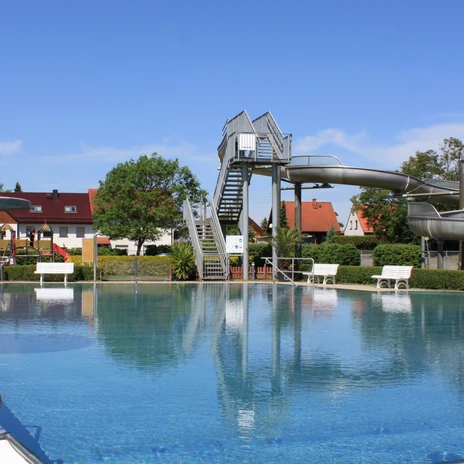 La piscine en plein air de Schildau offre, en plus de la piscine, un grand toboggan et des bancs pour se reposer.