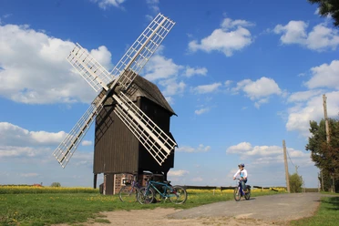 Bockwindmühle Kühnitzsch - Industriekultur in der Leipzig Region Blick auf die Bockwindmühle Kühnitzsch, im Vordergrund fährt ein Kind mit dem Fahrrad vorbei, Region, Industriekultur, Familienausflug