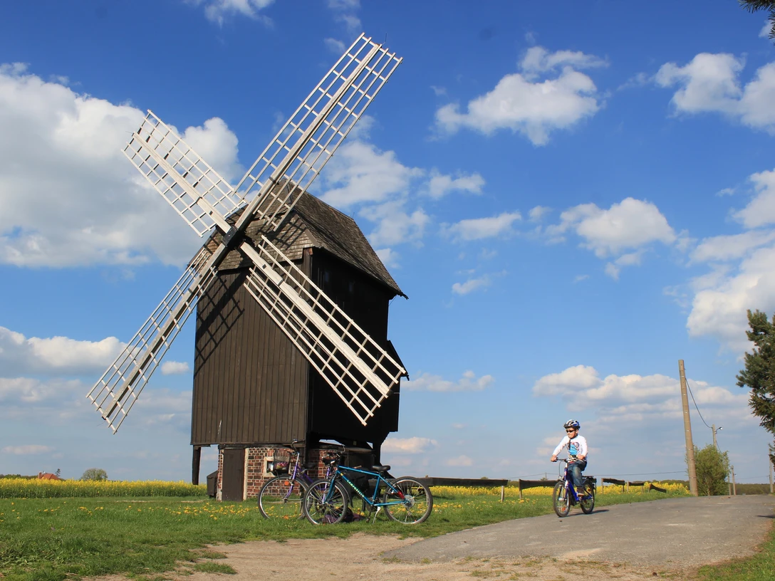 Bockwindmühle Kühnitzsch - Industriekultur in der Leipzig Region Blick auf die Bockwindmühle Kühnitzsch, im Vordergrund fährt ein Kind mit dem Fahrrad vorbei, Region, Industriekultur, Familienausflug