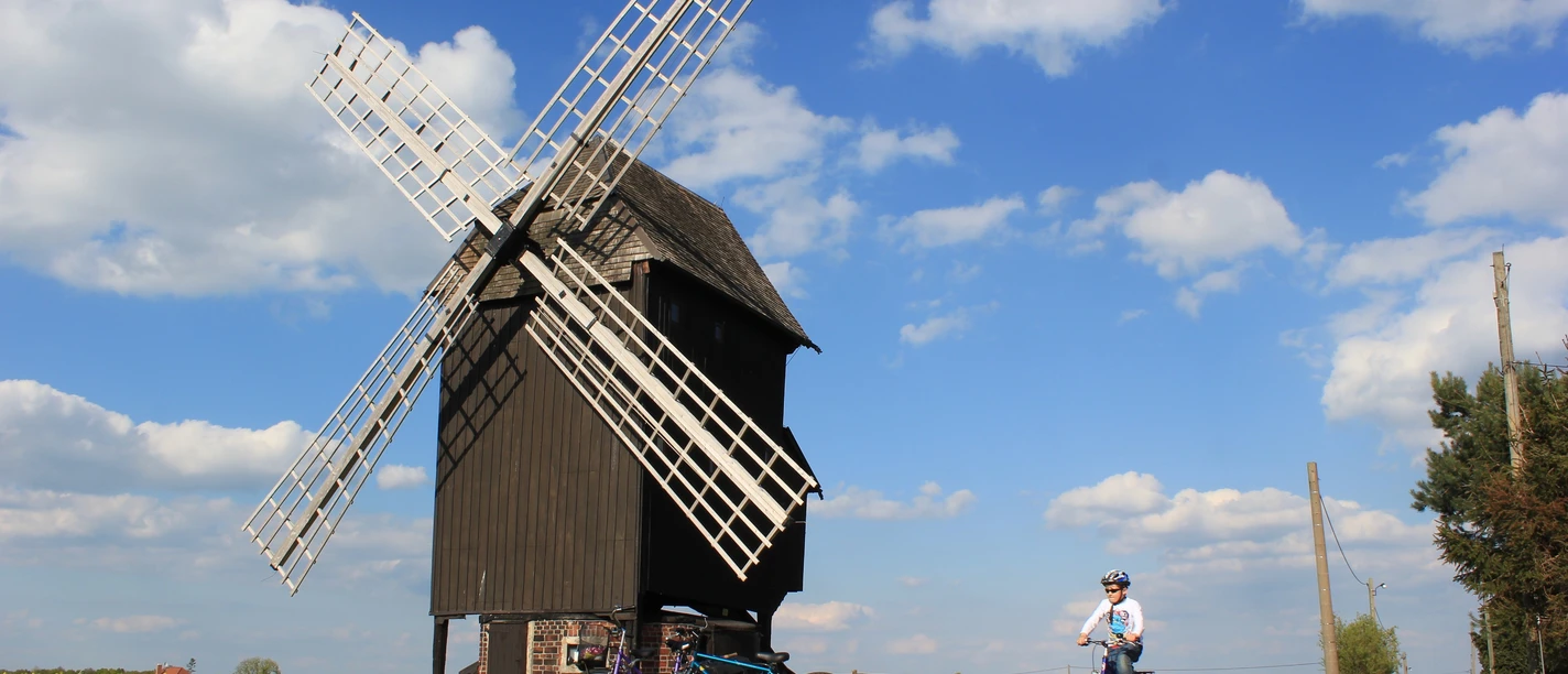 Bockwindmühle Kühnitzsch - Industriekultur in der Leipzig Region Blick auf die Bockwindmühle Kühnitzsch, im Vordergrund fährt ein Kind mit dem Fahrrad vorbei, Region, Industriekultur, Familienausflug