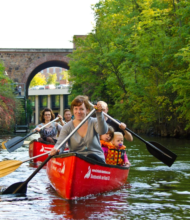 A family with children paddling two canoes across a canal in Leipzig, Leisure, Leipzig with children