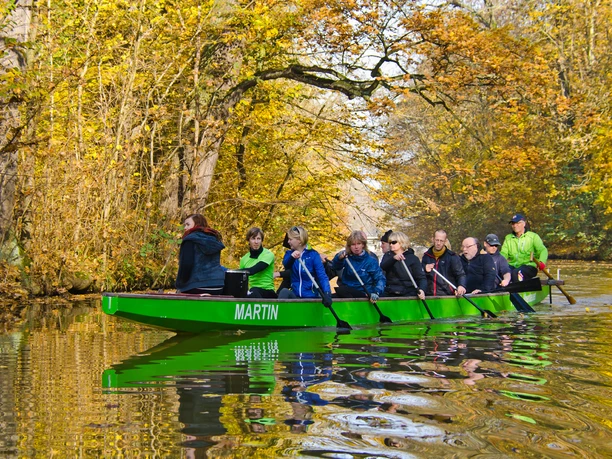 A full rowing boat discovers Leipzig's waterways in the floodplain forest in the fall, leisure, waterways