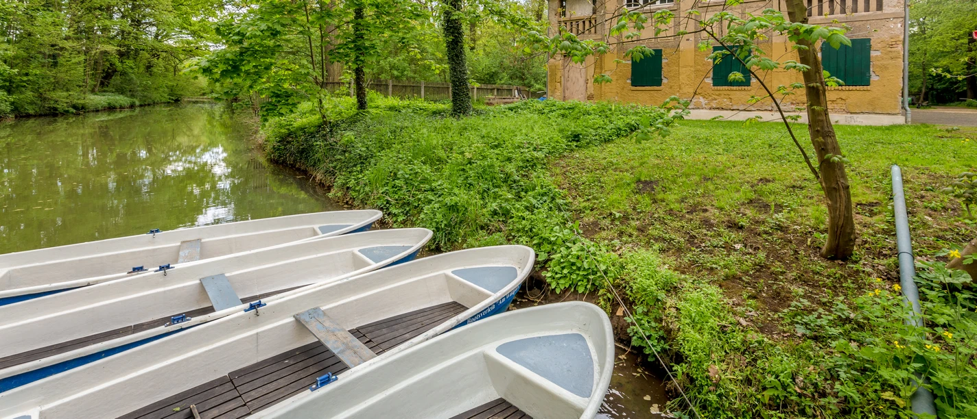 Lodě na vodě na přistávací ploše u půjčovny lodí ve Wildparku, rekreační zařízení v Lipsku, vodní sporty, kanoistika