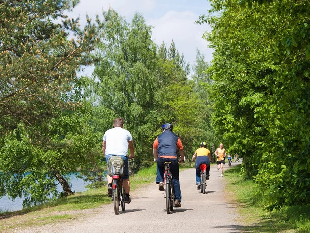Grupa rowerzystów jadących po asfaltowej ścieżce na skraju jeziora , Natura, Aktywny, Region