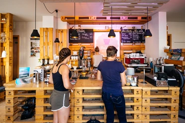 Brühbar Leipzig Tresen - Cafés in Leipzig Foto des Tresen-Bereiches der Brühbar, Besucher bestellen ihren Kaffee, Cafés, Kulinarik