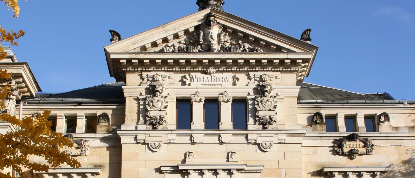 Pohled na Buddeho dům zvenčí - Kultura v Lipsku Na podzim si můžete prohlédnout vstupní prostor Buddeho domu. Je na něm vidět starý dům ve vilémovském stylu se dvěma sloupy u vchodu a balkonem. Budde-Hausen-Exteriér, Volný čas, Venkovní posezení, Kultura, Gastronomie