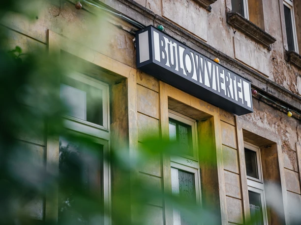 View of a worn façade in the Bülow district, with a lightbox sign with the same inscription above one of the doors, architecture, Gründerzeit