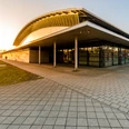 QUARTERBACK Immobilien ARENA - Veranstaltungen in Leipzig Der Eingang zur QUARTERBACK Immobilien ARENA Leipzig in der Abendsonne, die als Sportstätte, aber auch als Bühne und Ort für Veranstaltungen wie Konzerte genutzt wird.