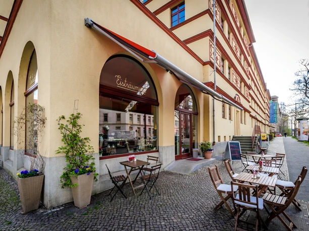 Eisträumerei Leipzig - Eisdielen & Cafés in Leipzig Eckansicht des Außenbereiches der Eisträumerei mit Café-Garnituren, Schaufenstern, Pflanzen und den angrezenden Straßenzug, freisitz, cafe, eisdiele