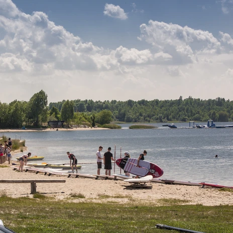 Jezioro Schladitz z wioślarzami stojącymi na brzegu