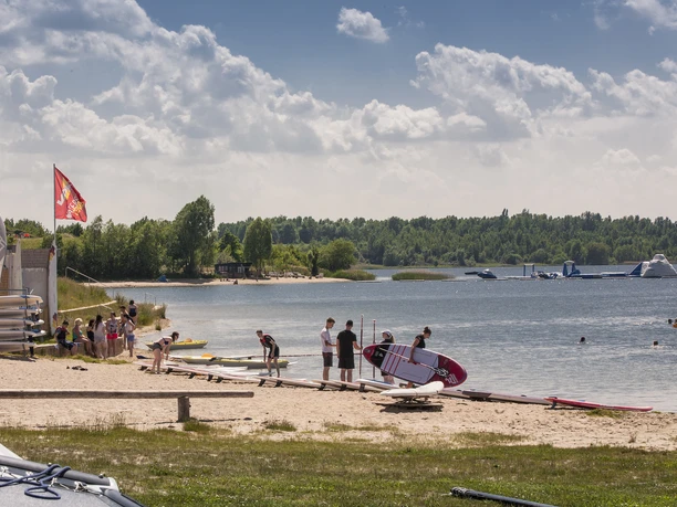 Wassersportstation am Schladitzer See - Leipziger Neuseenland Schladitzer See mit Stand Up Paddlern am Strandufer stehend