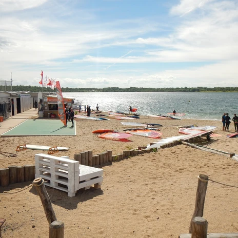Au bord de la plage du lac Schladitz, des sportifs veulent essayer la planche à voile sur le lac.