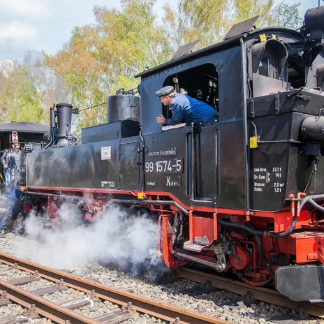 Strojvedoucí dráhy Döllnitzbahn "Wilder Robert" se dívá z okna úzkorozchodné železnice.