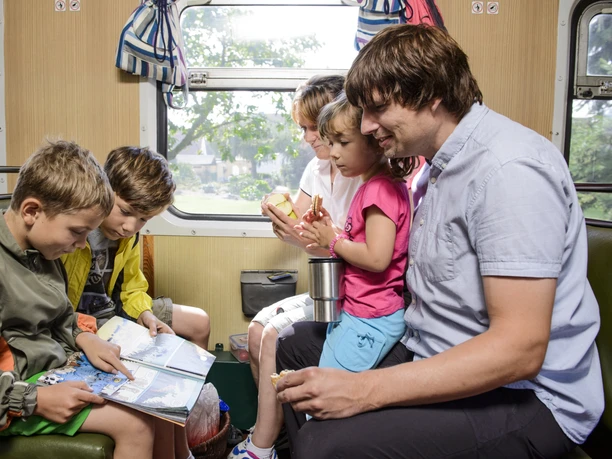 Excursion on the "Wilder Robert" narrow-gauge railroad - Holidays in the Leipzig region Family sitting in a train compartment of the Döllnitzbahn "Wilder Robert",, Excursion destinations, Leisure time