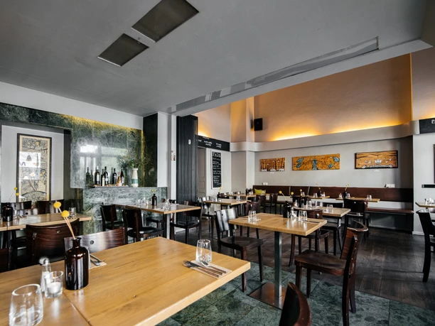 Fela - Gastronomie in Leipzig Blick in den Innenraum des Fela Restaurants, seine Tische und Dekorationen sowie die restliche moderne Inneneinrichtung