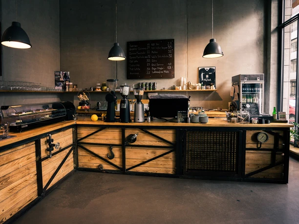Franz Morish - Kavárny v Lipsku Pohled na pult/ prodejní plochu Franz Morish; lampy, nábytek, prodej zrnkové kávy, baristické stroje, kavárna, gastronomie.
