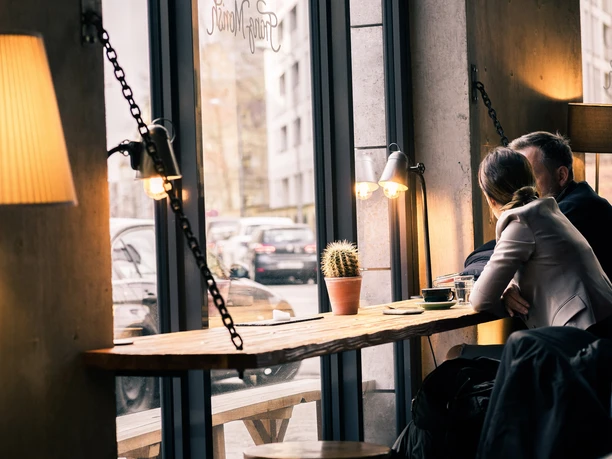 Franz Morish - Cafés in Leipzig Foto von Gästen, welche an einem der Fensterplätze sitzen und bei einem Kaffee auf die Straße sehen; Ambiente, Beleuchtung, cafe, kulinarik