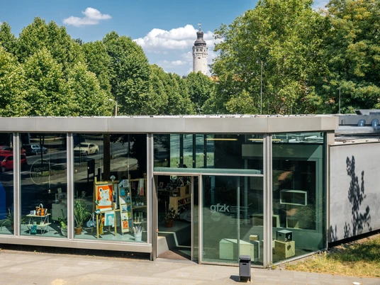 Galerie für Zeitgenössische Kunst - Kunst in Leipzig Blick auf den modernen Glasbau der GfZK an einem Sommertag mit blauem Himmel und Turm des Neuen Rathauses im Hintergrund, Kunst, Kultur, Ausstellungshaus