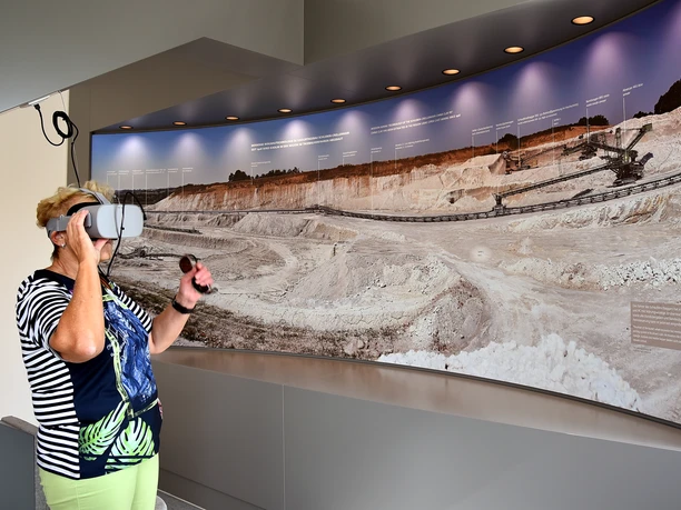 Une femme porte des lunettes de réalité virtuelle au géoportail de la gare de Mügeln dans le monde de l'aventure du kaolin, excursion, exposition, famille