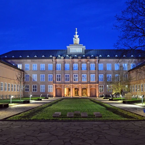 Widok na imponujący oświetlony budynek mieszczący Muzeum Sztuki Użytkowej Grassi nocą.