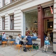 Gustav H. - Eisdielen & Eiscafés in Leipzig Blick auf die Fassade und den Freisitz des Gustav H., mit schlemmenden Gästen und spielenden Kindern, eisdiele, eiscafe, gastronomie