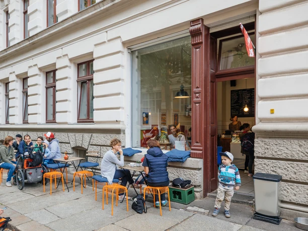 Gustav H. - Eisdielen & Eiscafés in Leipzig Blick auf die Fassade und den Freisitz des Gustav H., mit schlemmenden Gästen und spielenden Kindern, eisdiele, eiscafe, gastronomie