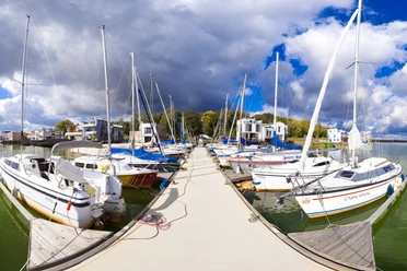 Segelhafen am Hainer See im Leipziger Neuseenland Der Segelhafen am Hainer See zeigt an einem sonnigen Tag stilvolle Segelboote an Anlegestellen.