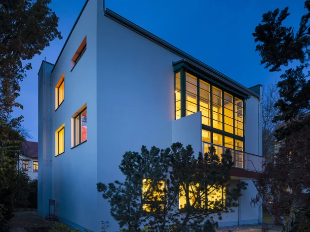 La maison Rabe à Leipzig, de style Bauhaus, est éclairée à l'intérieur et illumine ainsi le ciel nocturne
